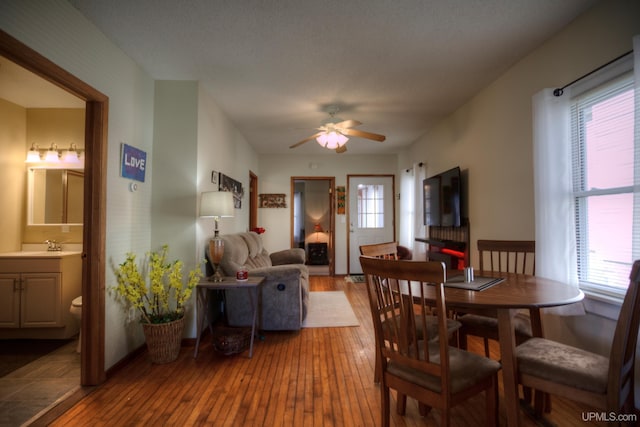 dining area with a wealth of natural light, hardwood / wood-style flooring, and ceiling fan