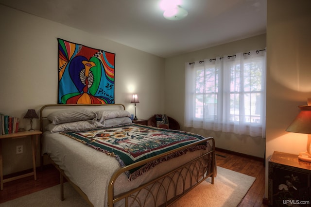 bedroom with wood finished floors and baseboards