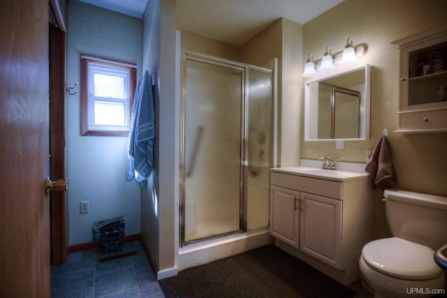 bathroom with toilet, a stall shower, vanity, and baseboards