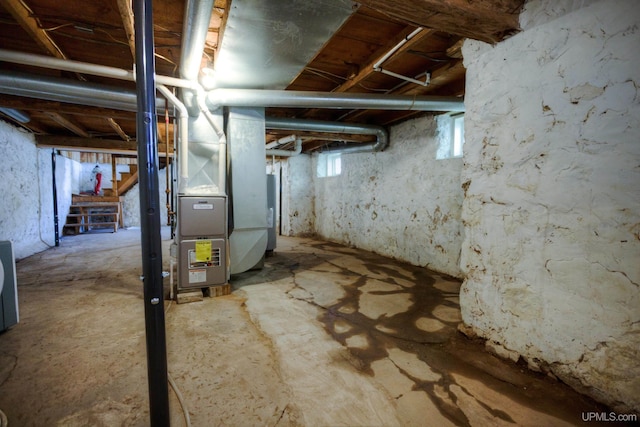 below grade area featuring heating unit, water heater, and stairs
