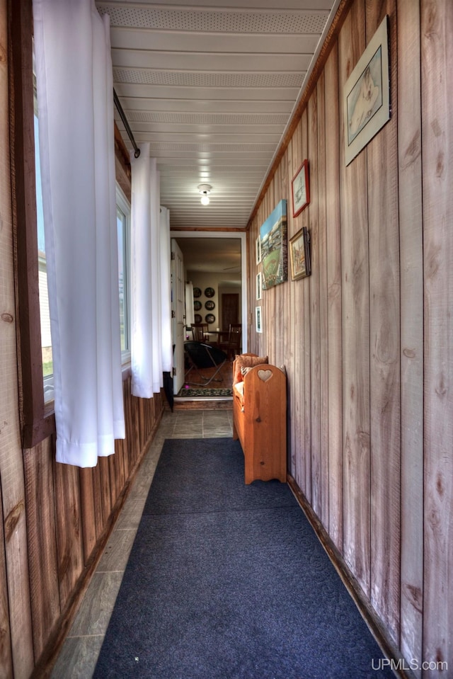 corridor featuring wood walls