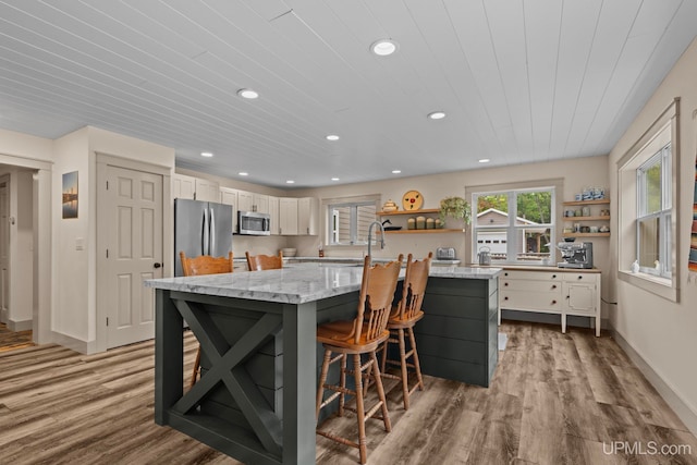 kitchen featuring appliances with stainless steel finishes, wood finished floors, open shelves, and recessed lighting