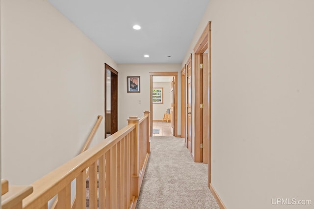 corridor with an upstairs landing, recessed lighting, and light carpet
