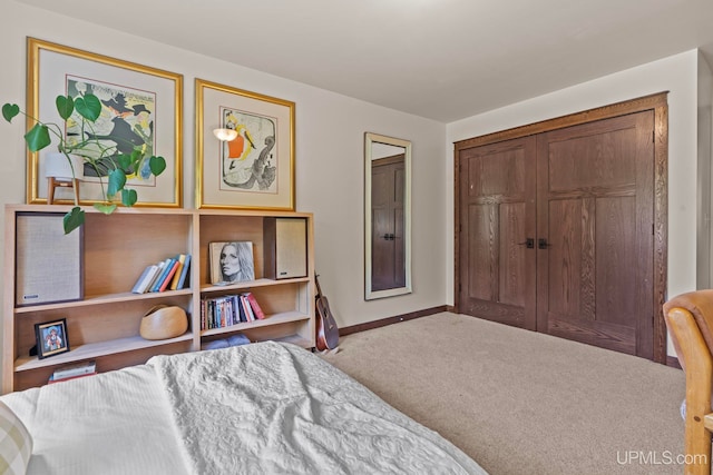carpeted bedroom featuring a closet and baseboards