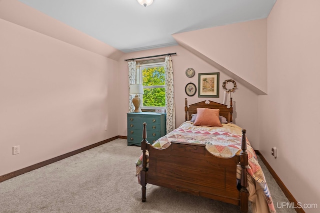 carpeted bedroom with lofted ceiling and baseboards