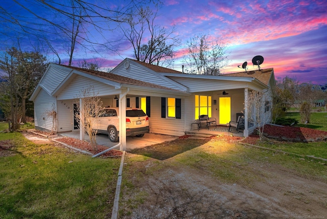 rear view of house with a lawn, a carport, and driveway