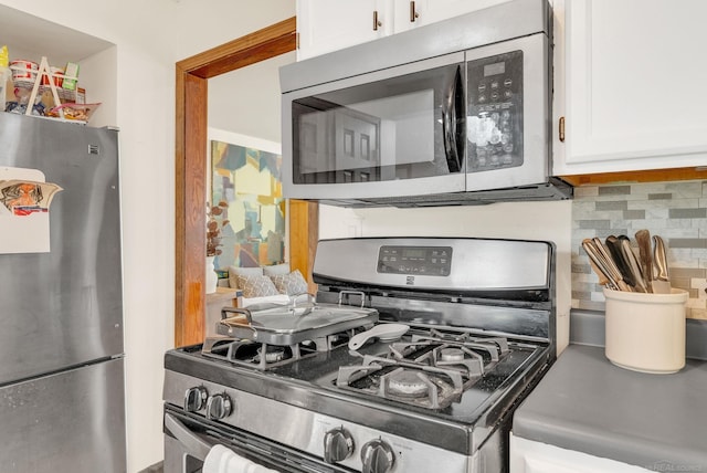 kitchen featuring white cabinetry, stainless steel appliances, and backsplash