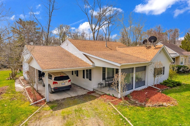 back of house with a carport, a yard, dirt driveway, and roof with shingles