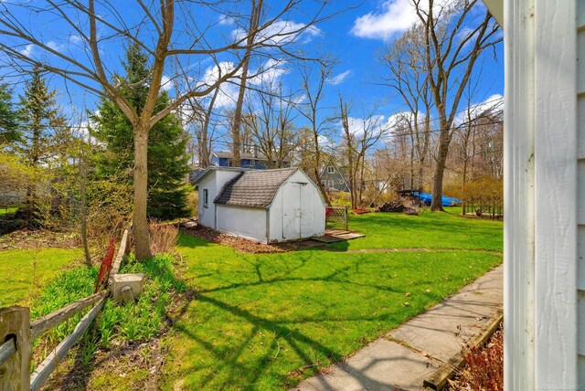view of yard featuring a storage unit, fence, and an outbuilding