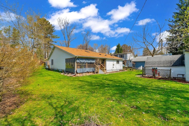 rear view of house with a sunroom and a yard