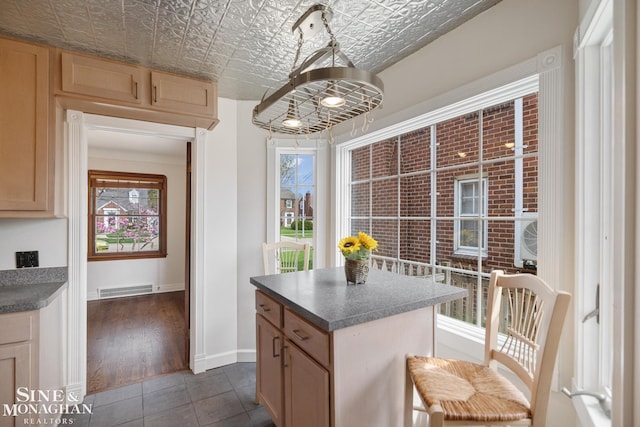 kitchen featuring an ornate ceiling, visible vents, plenty of natural light, and baseboards