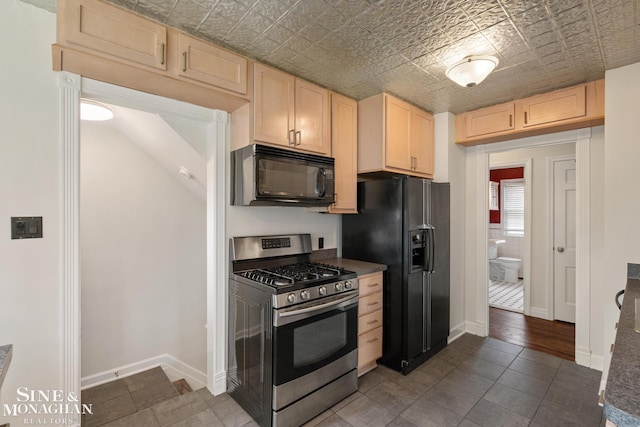 kitchen with black appliances, an ornate ceiling, dark countertops, and light brown cabinetry