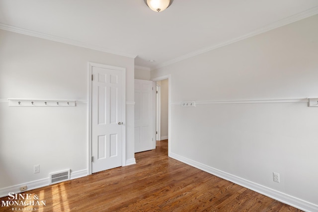 unfurnished bedroom featuring baseboards, visible vents, ornamental molding, and wood finished floors