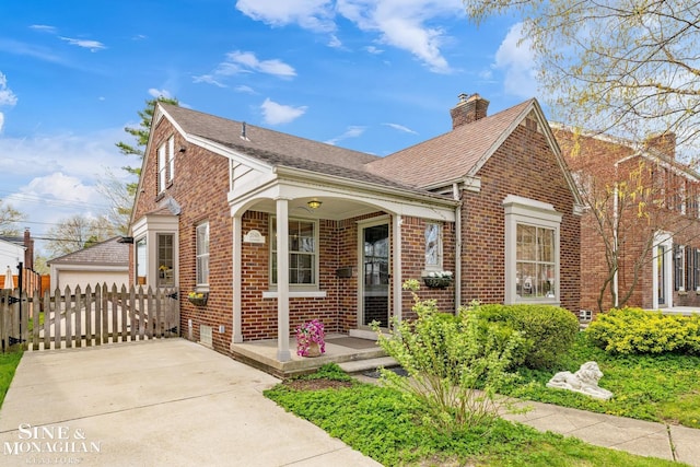 view of front of property featuring a chimney, roof with shingles, fence, a porch, and brick siding