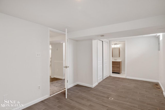 finished basement featuring visible vents, wood finished floors, and baseboards