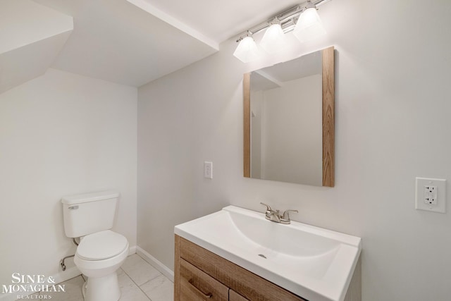 bathroom featuring toilet, marble finish floor, vanity, and baseboards
