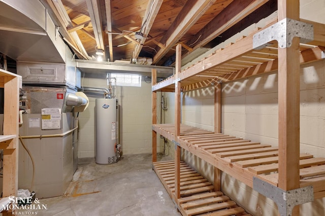 basement with concrete block wall, heating unit, and water heater