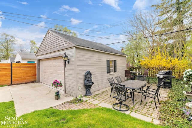 exterior space featuring fence, outdoor dining area, and an outbuilding