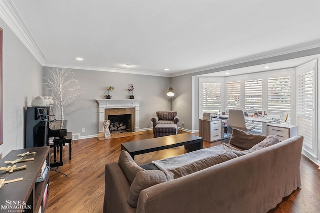 living area with a fireplace, recessed lighting, baseboards, wood finished floors, and ornamental molding