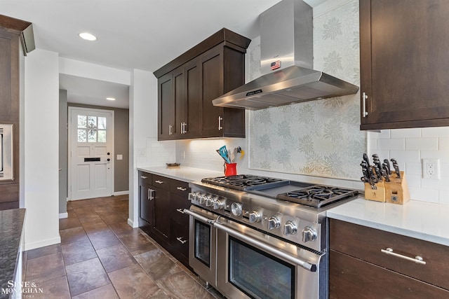 kitchen with light countertops, range with two ovens, dark brown cabinetry, and extractor fan