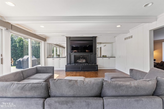 living area with visible vents, crown molding, a decorative wall, beamed ceiling, and recessed lighting