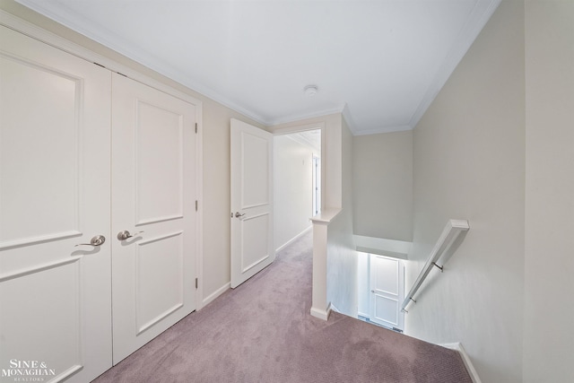 hallway featuring baseboards, crown molding, light carpet, and an upstairs landing