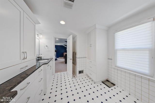bathroom featuring visible vents, recessed lighting, tile walls, and vanity