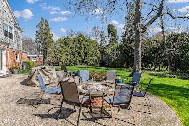 view of patio with a trampoline and an outdoor fire pit