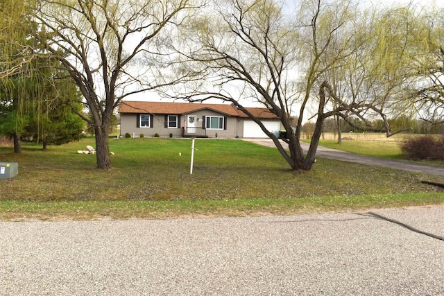 ranch-style home featuring driveway, a front yard, and a garage