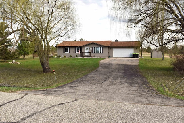 ranch-style house featuring a garage, aphalt driveway, a shed, and a front yard