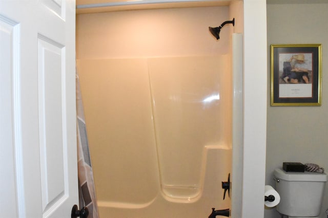 full bathroom featuring a shower and toilet