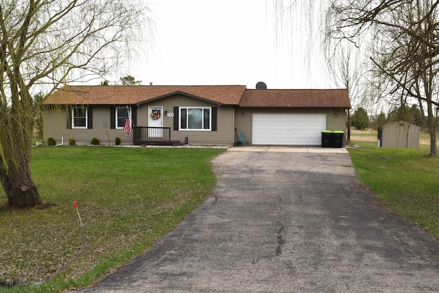ranch-style house featuring an attached garage, driveway, a shed, and a front yard