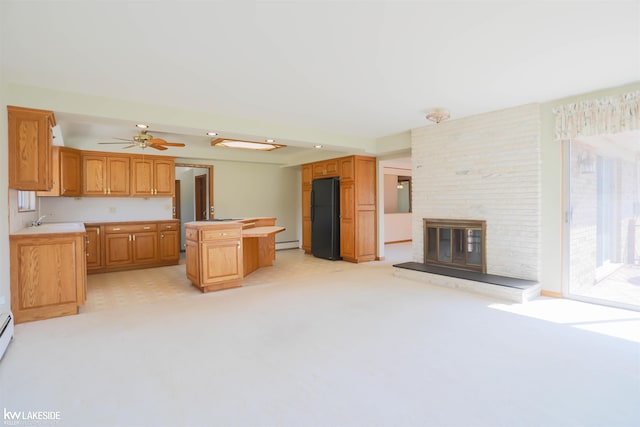 2428 Irma St, Warren, MI 48092 - kitchen with a kitchen island, a fireplace, light countertops, freestanding refrigerator, and a baseboard heating unit