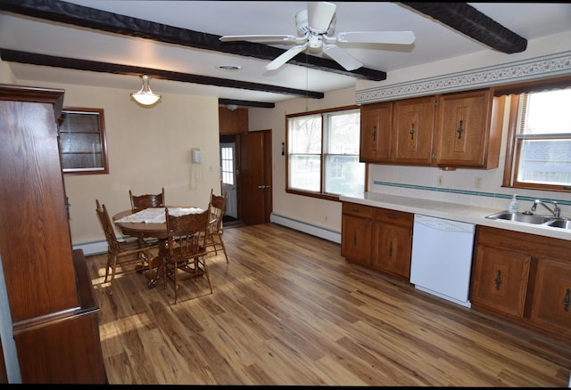 kitchen featuring white dishwasher, light countertops, a sink, beamed ceiling, and a baseboard heating unit
