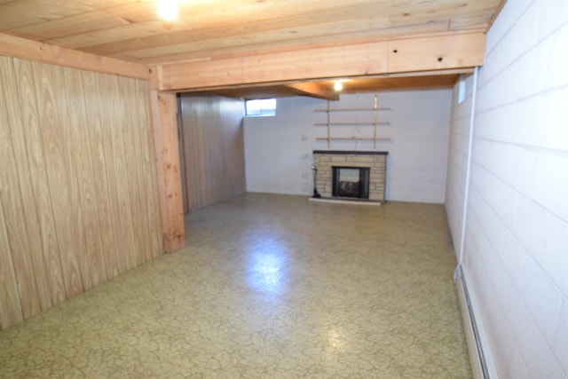 basement with a fireplace with raised hearth and a baseboard heating unit