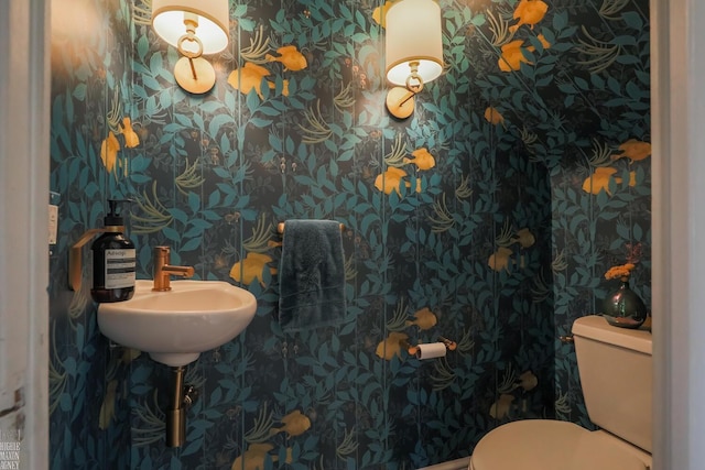half bath featuring toilet and wallpapered walls