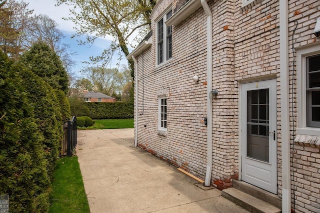 view of home's exterior with brick siding and a patio area