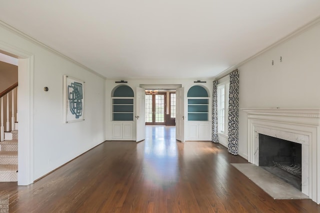 unfurnished living room with dark wood-type flooring, a high end fireplace, built in shelves, and stairway