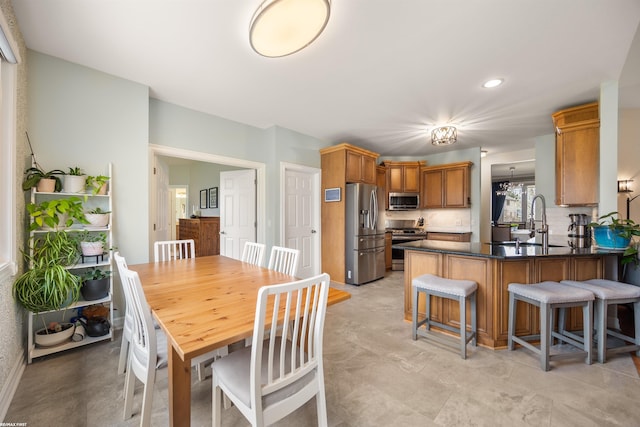 interior space featuring a peninsula, dark countertops, a breakfast bar, a sink, and appliances with stainless steel finishes