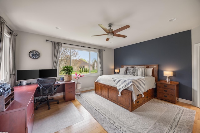 bedroom featuring baseboards, light wood-style flooring, and ceiling fan