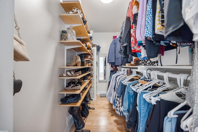walk in closet with light wood-style floors