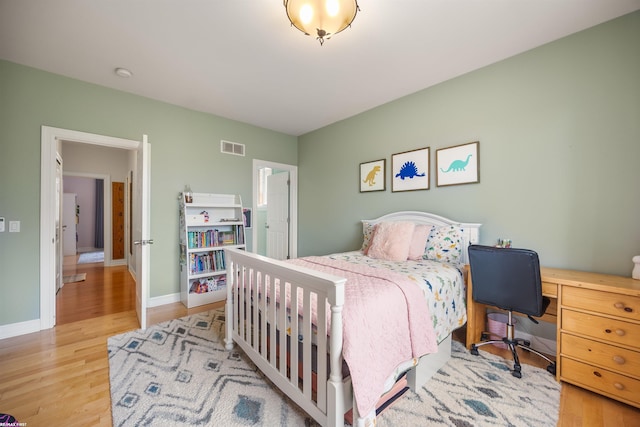 bedroom featuring light wood-style floors, baseboards, and visible vents