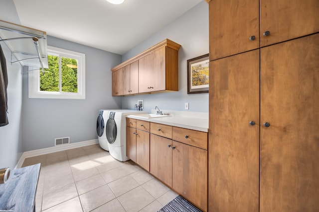 washroom with cabinet space, washing machine and clothes dryer, baseboards, light tile patterned floors, and visible vents