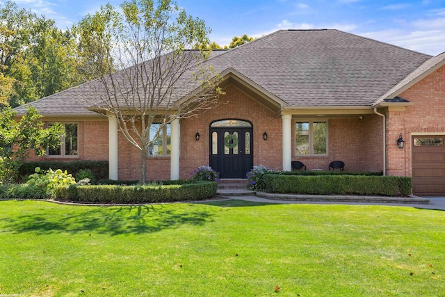 ranch-style house with brick siding, a shingled roof, and a front lawn