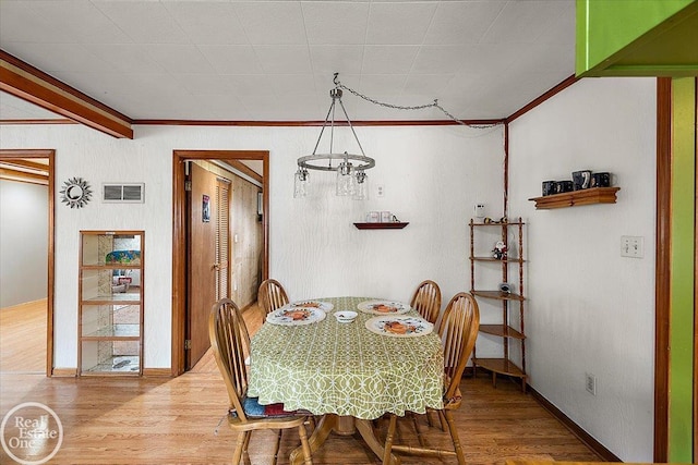 dining area featuring baseboards, ornamental molding, wood finished floors, and visible vents