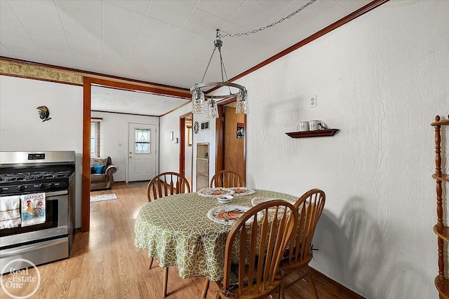dining room with ornamental molding and wood finished floors