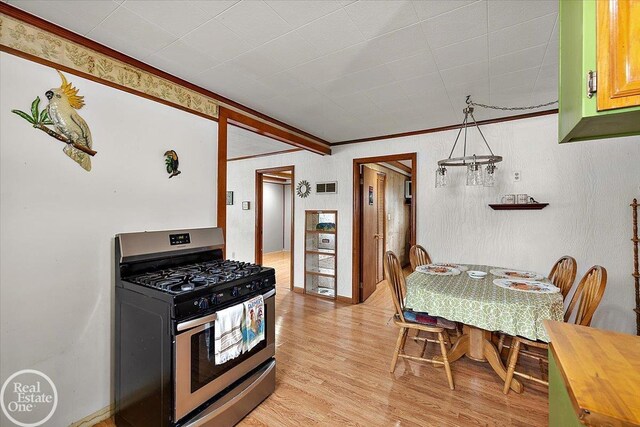 kitchen with wooden counters, visible vents, crown molding, light wood-type flooring, and stainless steel gas range