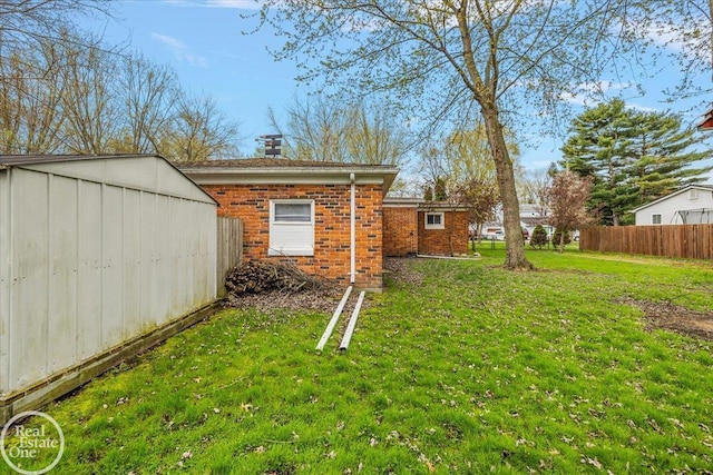view of yard featuring a storage shed, fence, and an outdoor structure
