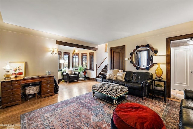 living room featuring stairway, wood finished floors, and a notable chandelier