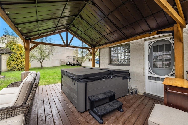 wooden terrace featuring a hot tub, a lawn, and a gazebo
